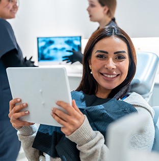 Woman smiling while holding handheld mirror