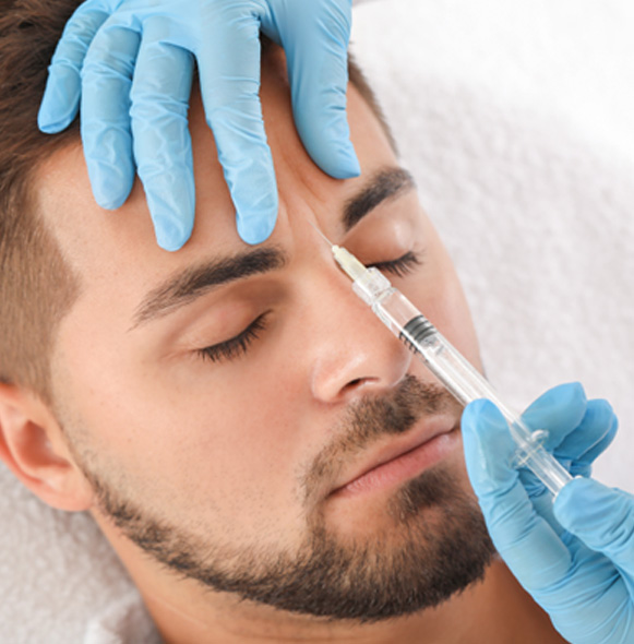 Man receiving BOTOX injection between his eyebrows