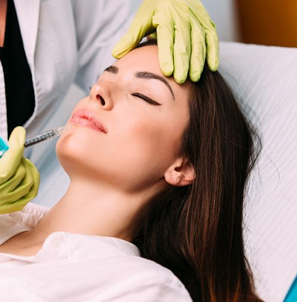 Woman receiving dermal filler injection in her lips