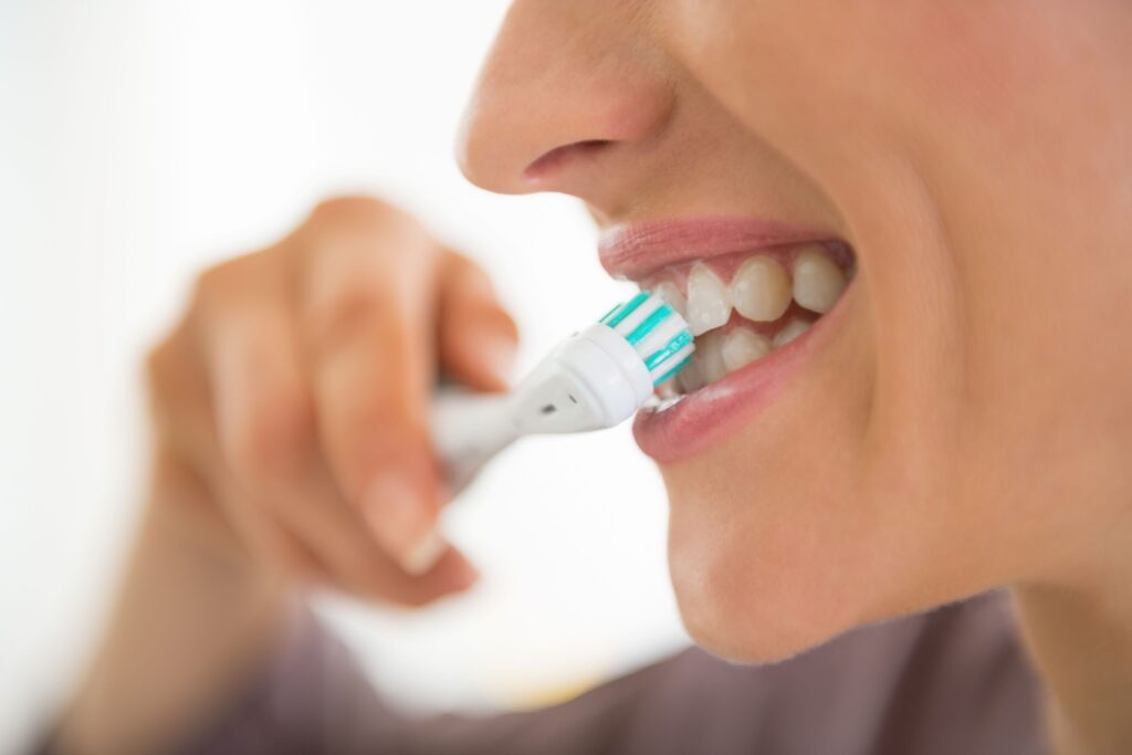 Profile nose-to-chin view of woman brushing teeth